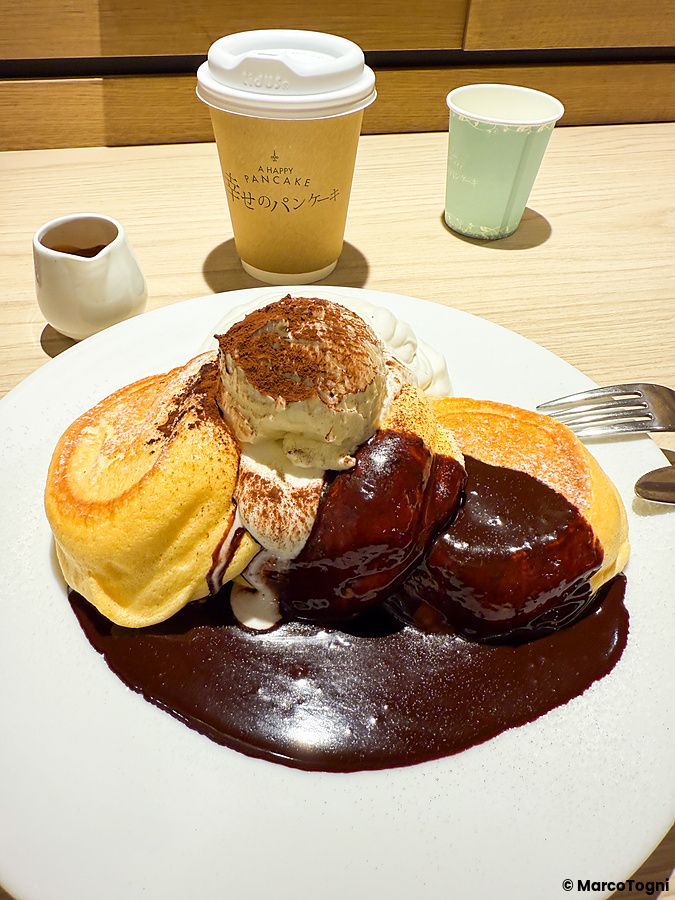 Pancake con cioccolato fuso e gelato serviti in un piatto bianco presso A Happy Pancake in Giappone.