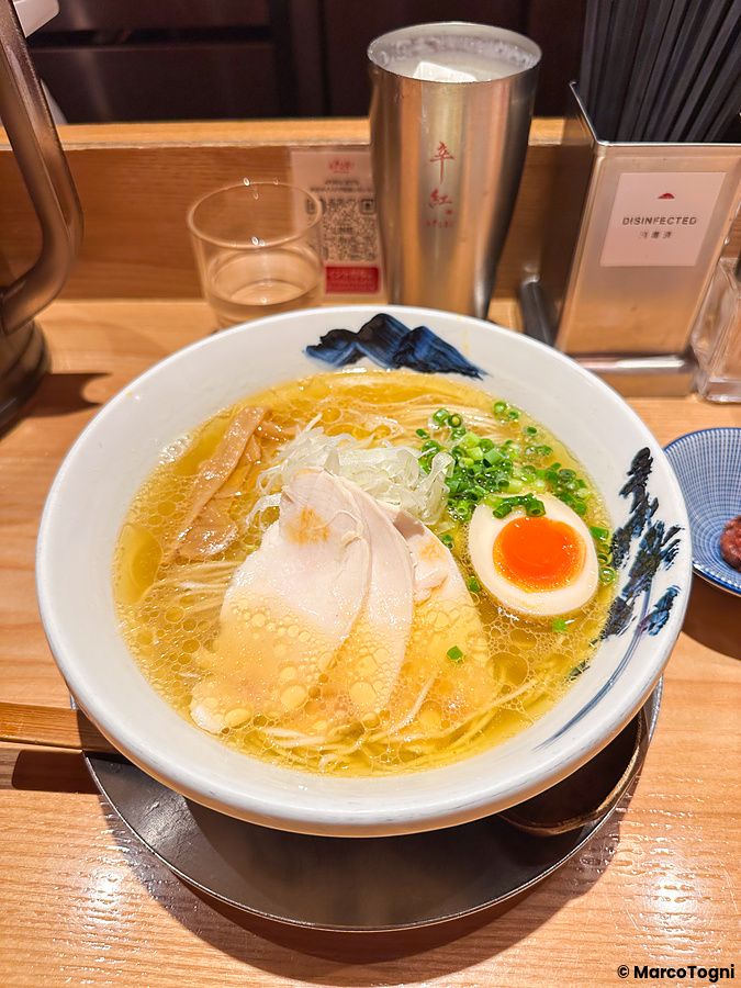 Un ramen a Afuri servito in una ciotola bianca su un bancone di legno presso il ristorante Afuri Karakurenai a Shinjuku.