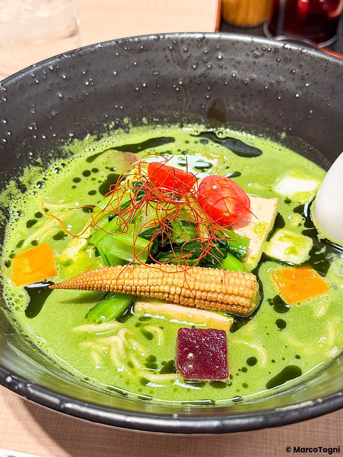 Una ciotola di ramen vegano con brodo al matcha guarnita con verdure presso il ristorante Yoroiya ad Asakusa.