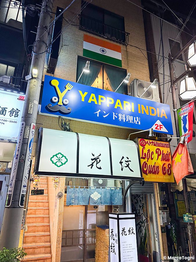 L'insegna blu del ristorante indiano Yappari India, a Otsuka (Tokyo), posizionata sopra l'ingresso al secondo piano.