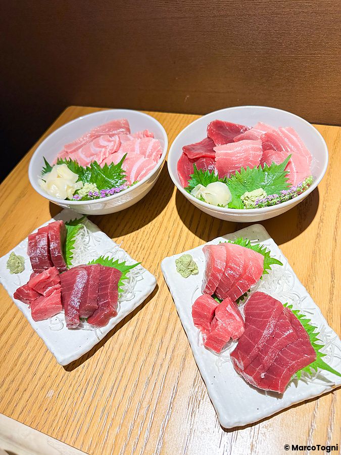 Sashimi e donburi di tonno serviti su tavoli di legno presso il ristorante Tekka Ya Hiei al mercato di Tsukiji.