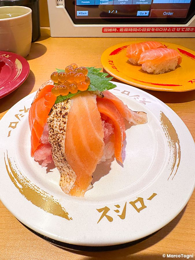 Piatti di sushi con salmone e uova di pesce serviti su tavoli con tablet per l'ordine al Ristorante Sushiro.