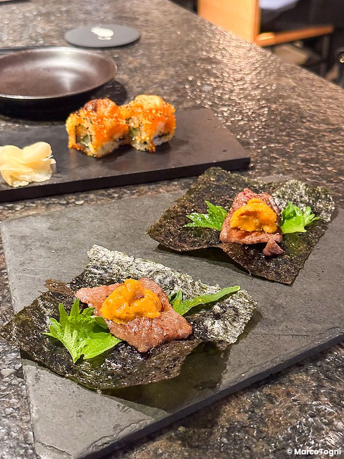 Wagyu e riccio di mare su alga nori serviti su una lastra di pietra al Kinka Sushi Bar Izakaya di Shibuya.