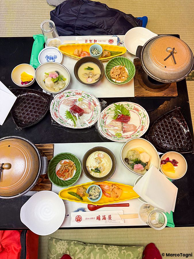 Tavolo imbandito con piatti tipici giapponesi a bordo di una Yakatabune, l'imbarcazione tradizionale di Tokyo.