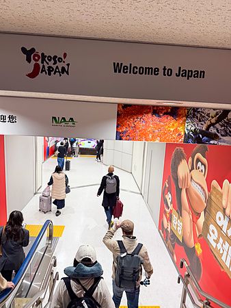 persone camminano nel corridoio di arrivo dell'aeroporto di Narita, Giappone.