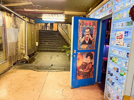 Ingresso di un locale con porta blu e collezione di bicchieri di sake presso la Asakusa Underground Street a Tokyo.