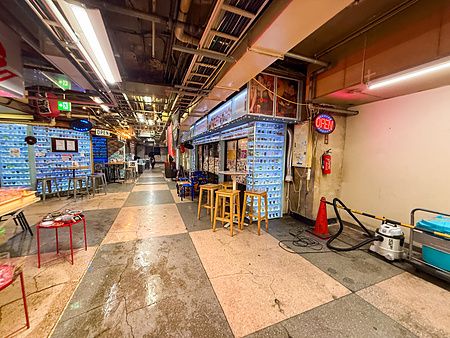 Interno della Asakusa Underground Street con negozi retrò, sgabelli in legno e insegne al neon in un corridoio sotterraneo.