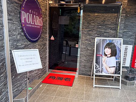 Ingresso di un locale Soapland in Giappone con poster e cartello.