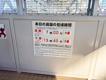 Cartello informativo sugli orari migliori per vedere i vortici di Naruto nel giorno della visita presso lo stretto di Naruto.