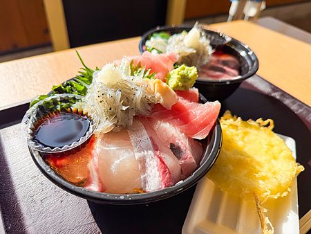 Due ciotole di donburi con pesce crudo servite su un vassoio presso il ristorante Osakana Kyowakoku Ebisu Maru.