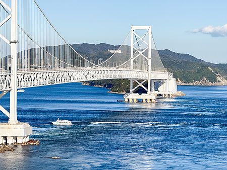 Veduta del ponte con i vortici a Vortice di Naruto che attraversa lo stretto con correnti marine evidenti.
