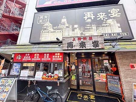 L'esterno a Sairaien a Ueno con insegne del ristorante, menu esposti e una bicicletta parcheggiata davanti all'ingresso.