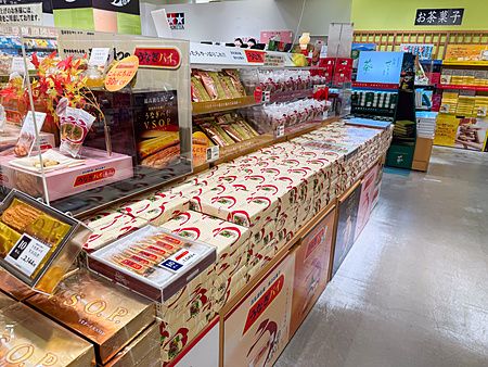 Interno di un negozio in una stazione di servizio in autostrada in Giappone con espositori pieni di confezioni regalo.