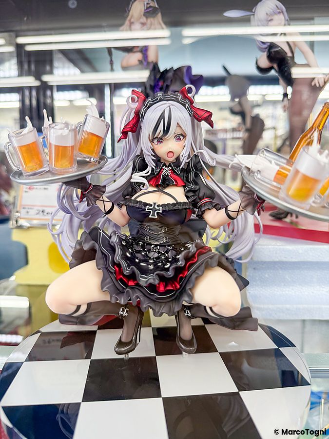 Una statuetta anime in abito gotico con vassoi di birra esposta in una vetrina presso amiami Akihabara Figure Tower.