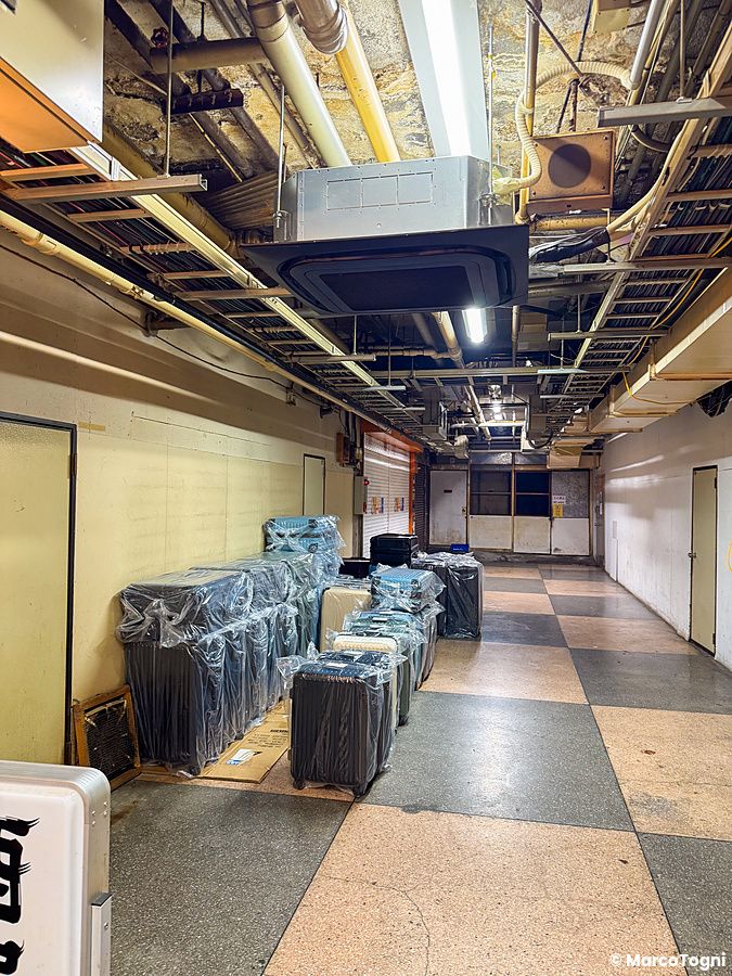 Una fila di valigie avvolte nella plastica lungo il corridoio di Asakusa Underground Street a Tokyo.