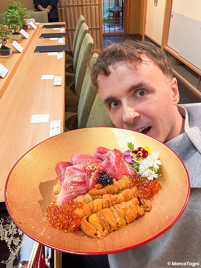 Marco Togni mostra un piatto donburi premium con ikura, riccio di mare, chutoro e otoro nel ristorante Waunn a Asakusa.