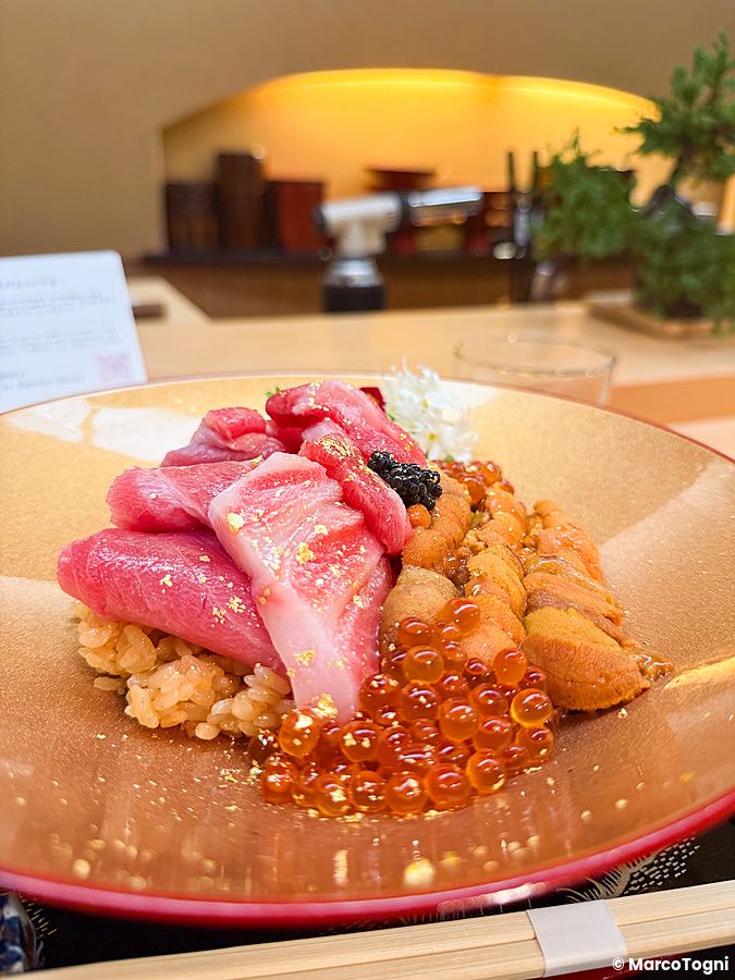 Donburi premium con ikura, riccio di mare, chutoro e otoro servito in una ciotola dorata al ristorante Waunn di Asakusa.