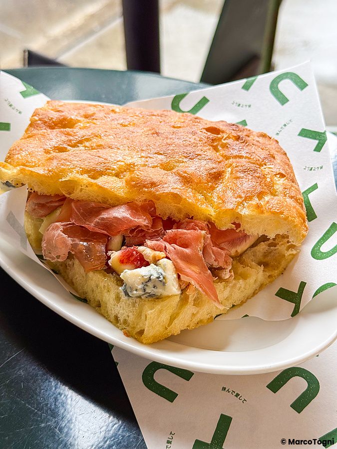 Focaccia con prosciutto, fichi e formaggio servita su un piatto presso il ristorante Tutu a Meguro.