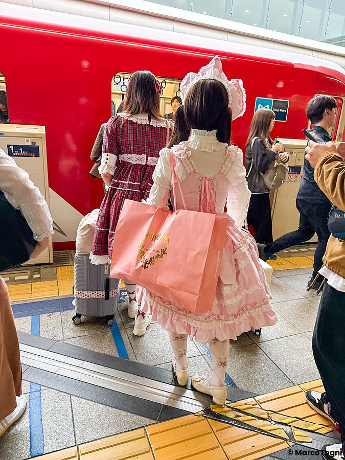 Persone con abbigliamento lolita in una stazione della metropolitana in Giappone.