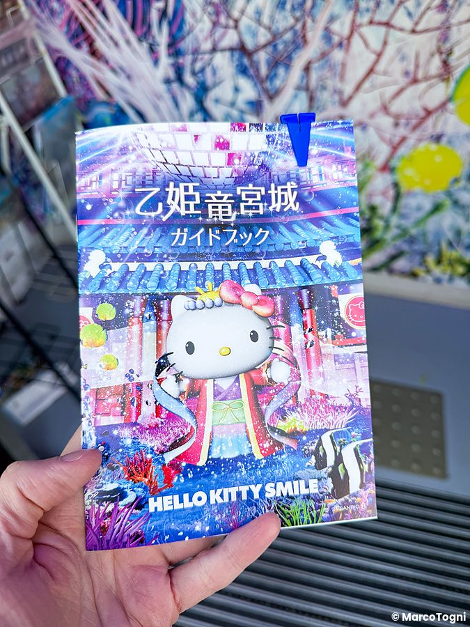 Una mano tiene la guida turistica del parco a tema Hello Kitty Smile sull'isola di Awaji, Giappone.