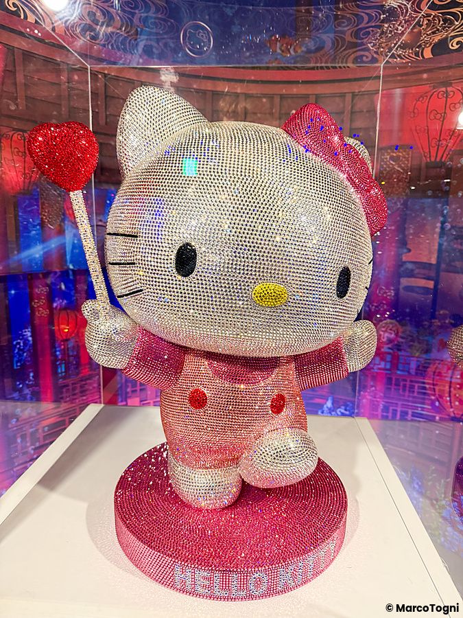 Una scultura di Hello Kitty ricoperta di cristalli colorati esposta in una teca a Hello Kitty Smile.