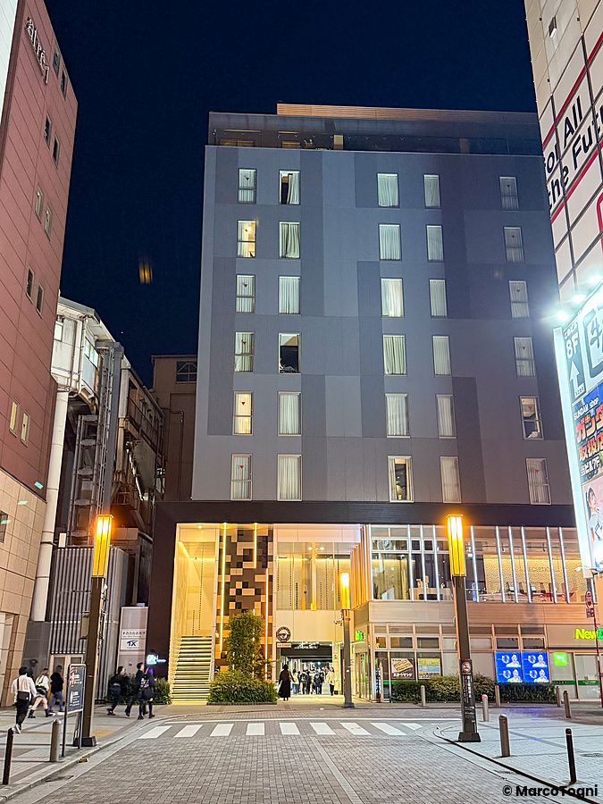 Veduta notturna dell'esterno del JR East Hotel Mets Premier Akihabara situato a fianco alla stazione ferroviaria.