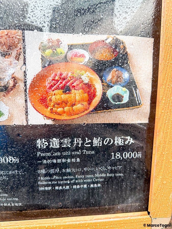Menu all'ingresso con l'immagine del donburi premium a Waunn, coperto da gocce di pioggia.
