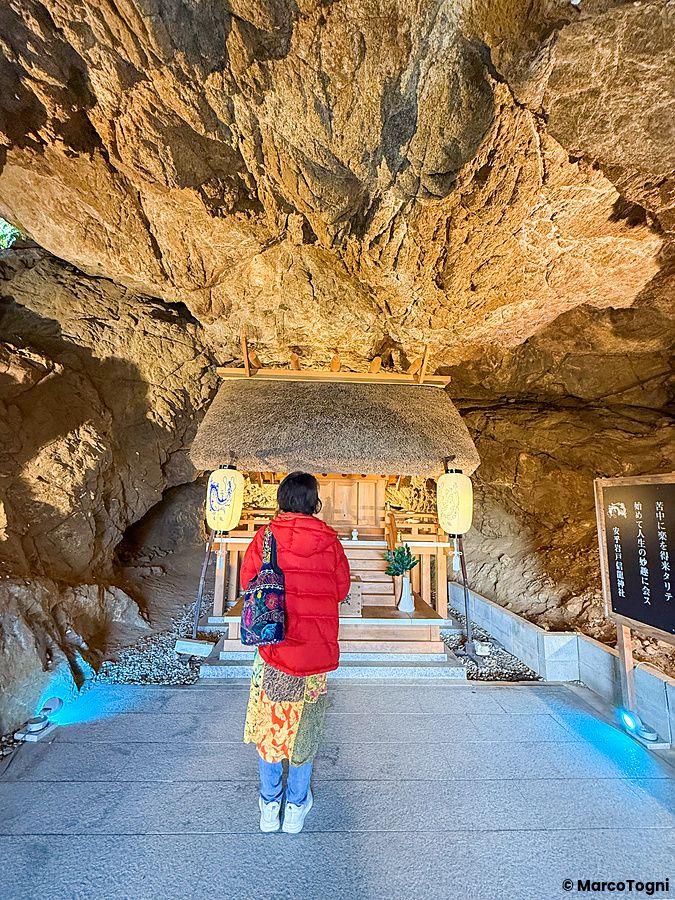 Una persona osserva il Santuario Aiga Iwato Shinryu, situato all'interno di una grotta sull'isola di Awaji, in Giappone.