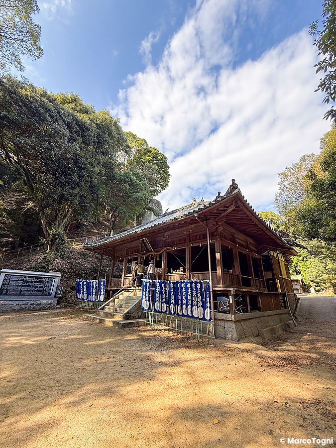Veduta frontale del Santuario Iwagami (Isola di Awaji, Giappone) con il suo grande masso sacro sullo sfondo.