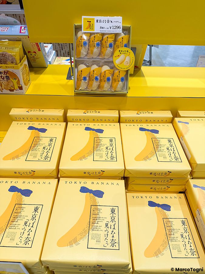 Scaffali gialli con confezioni dello snack Tokyo Banana in una stazione di servizio in autostrada in Giappone.