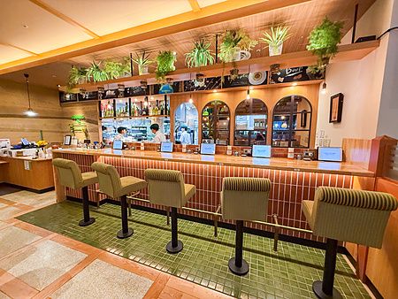 Il bancone in piastrelle di Komeda Is con sgabelli verdi in un interno curato nel quartiere di Ginza a Tokyo.