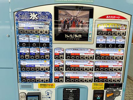 Distributore di bevande automatico per caffè situato a fianco ai binari del treno Shinkansen a Tokyo.