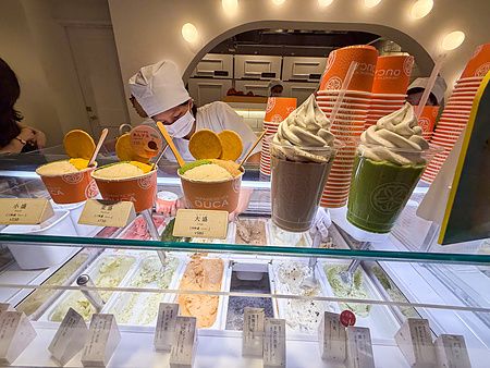Bancone espositivo di Ouca, gelateria giapponese a Ebisu, con gelato artigianale e una persona al lavoro.
