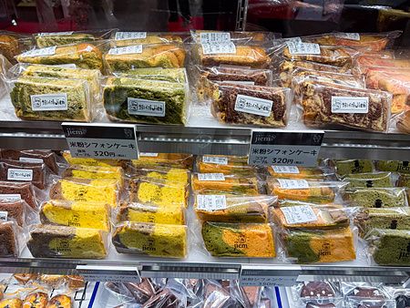 Una selezione di fette di torte chiffon confezionate, esposte in un banco frigo durante la Good Life Fair a Tokyo.