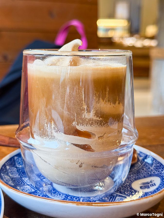 Un affogato servito in un bicchiere di vetro su un piattino decorato con motivi blu, presso il Takao Coffee.