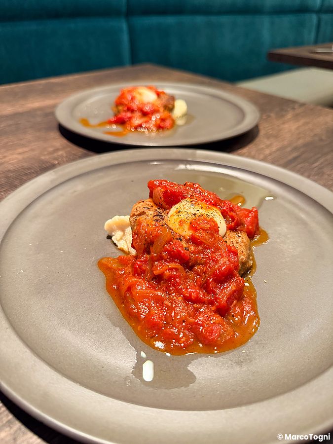 Due piatti con burger di carne vegana, piatto vegano a Green Italian Torcia, serviti su un tavolo in un ristorante.