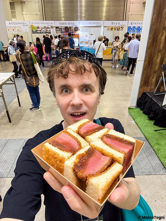 Marco Togni tiene in mano una confezione di panini vegano, non è carne! durante la Good Life Fair a Tokyo.