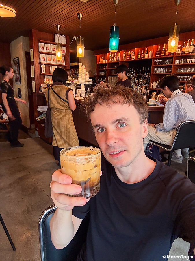 Marco Togni tiene un bicchiere di caffè nel locale Fuglen vicino alla stazione Yoyogi-Hachiman a Tokyo.
