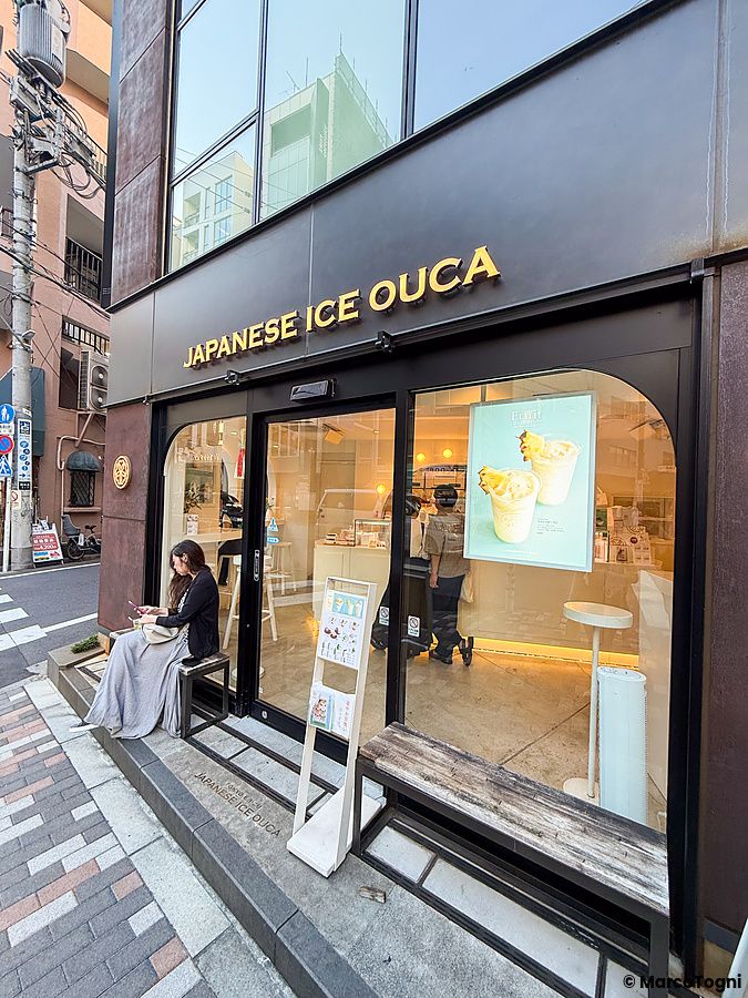 La facciata esterna della gelateria Ouca nel quartiere di Ebisu a Tokyo con una persona seduta sulla panchina.