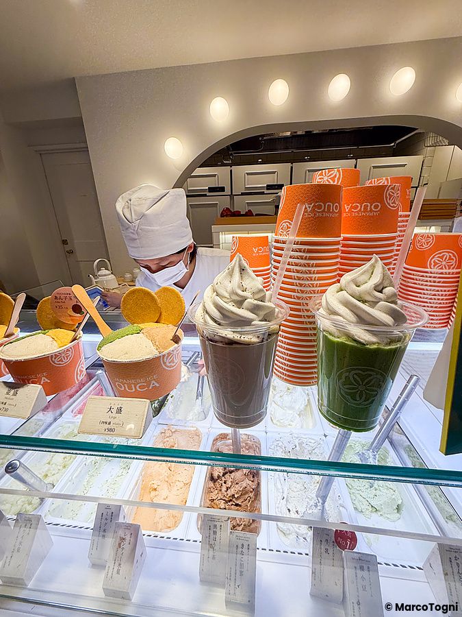 Il banco gelateria di Ouca ad Ebisu, Tokyo, con una persona che lavora e coppe di gelato in primo piano.