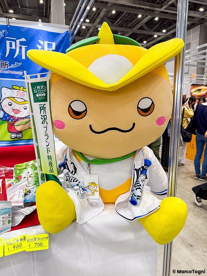 La mascotte gialla e bianca Tokororon è seduta su un banchetto espositivo alla Good Life Fair di Tokyo.