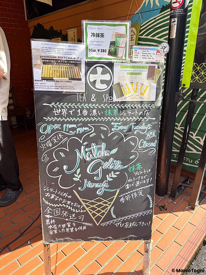 Lavagna informativa scritta a mano con gesso all'esterno del negozio di gelato al matcha Nanaya nel quartiere di Aoyama.