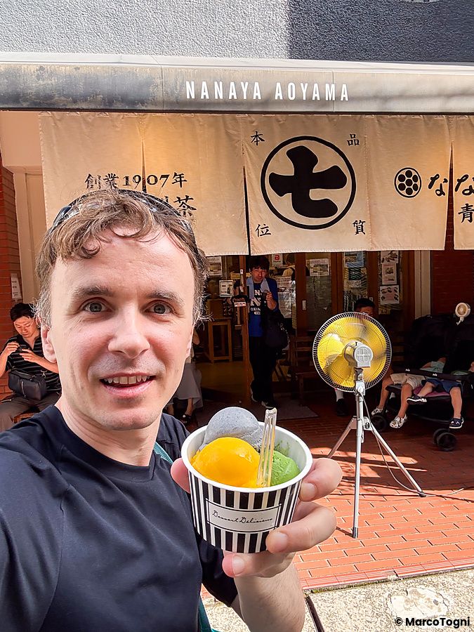 Marco Togni si scatta un selfie davanti all'ingresso del negozio Nanaya ad Aoyama, tenendo in mano una coppetta di gelato.