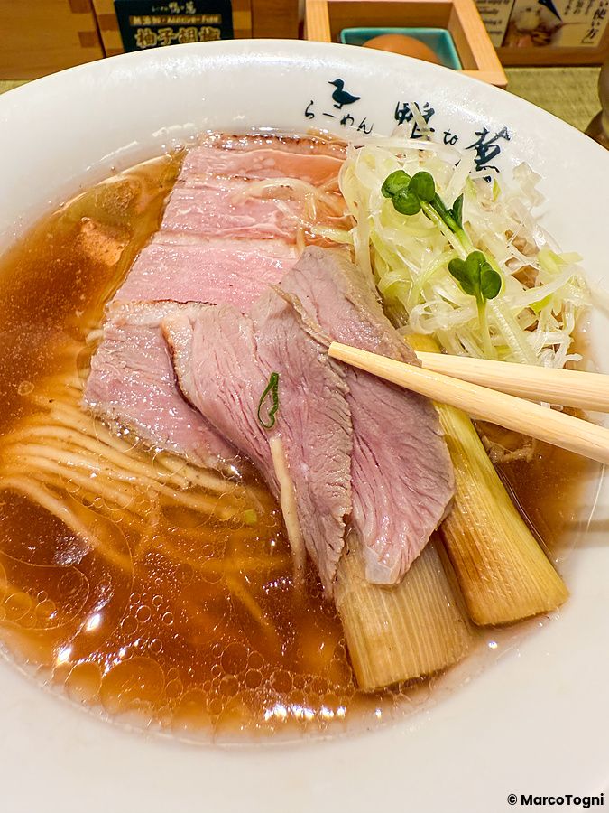 Una ciotola di ramen con fette di anatra e porri presso il ristorante Ramen Kamo to Negi, vista dall'alto.