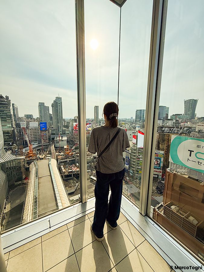 persona che guarda Shibuya dal centro commerciale Hikarie a Tokyo.