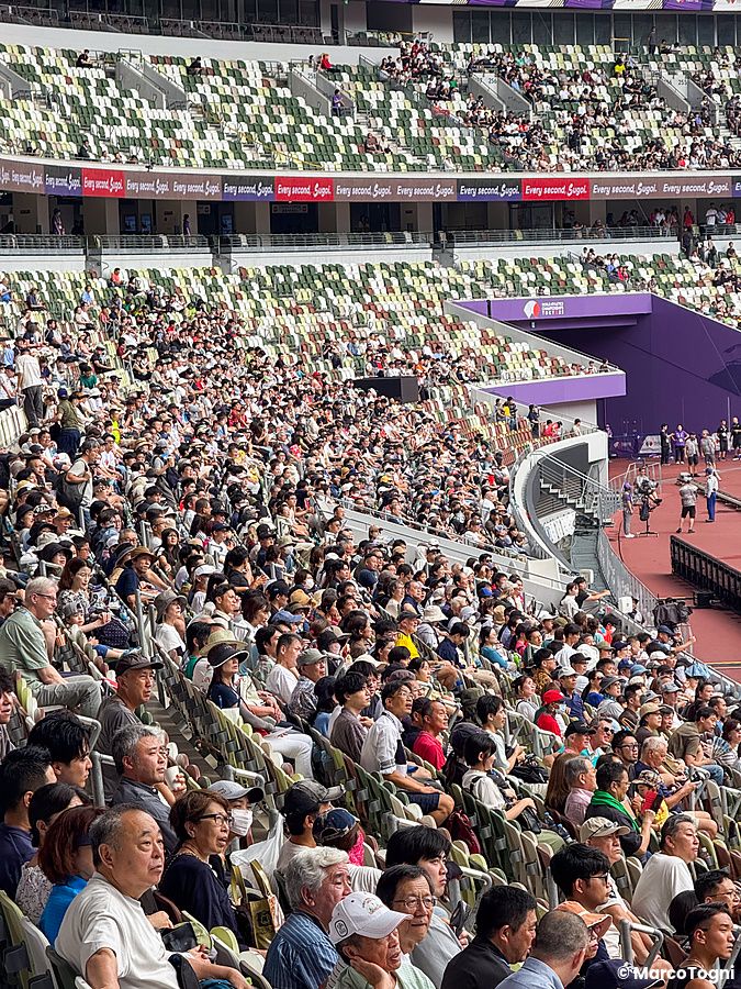 Veduta ravvicinata di una folla di persone seduta sugli spalti all'interno dello Stadio Nazionale Giapponese a Tokyo.