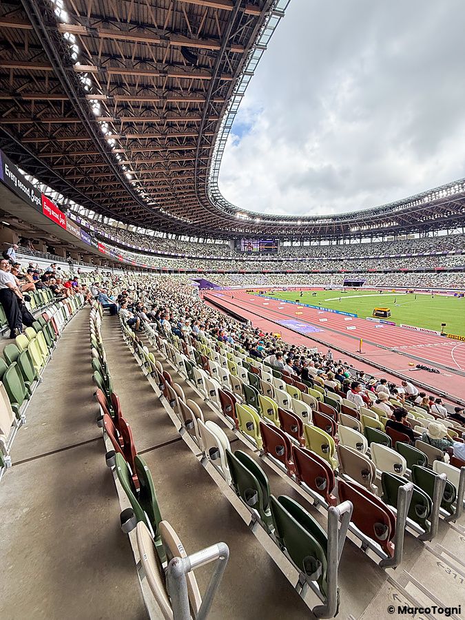 Veduta panoramica all'interno dello Stadio Nazionale Giapponese a Tokyo con spettatori seduti sugli spalti.