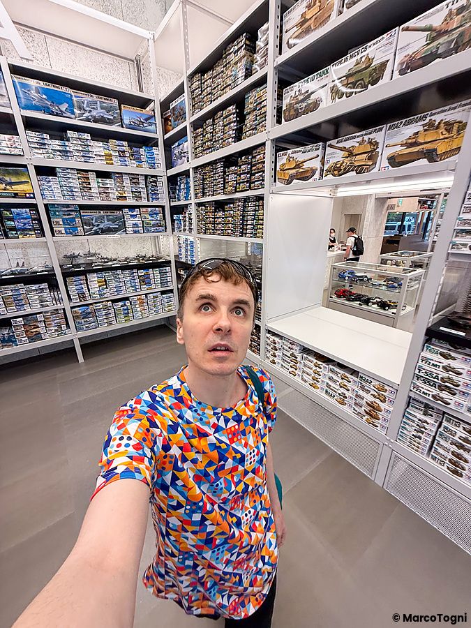 Marco Togni in una maglietta colorata si scatta un selfie all'interno del negozio Tamiya PlaModel Factory a Shimbashi.