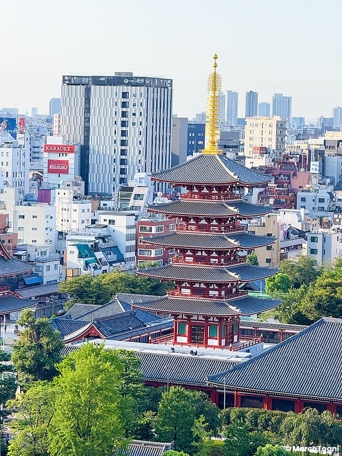 Panorama urbano di Asakusa con il tempio Senso-ji a Tokyo sotto un cielo azzurro.