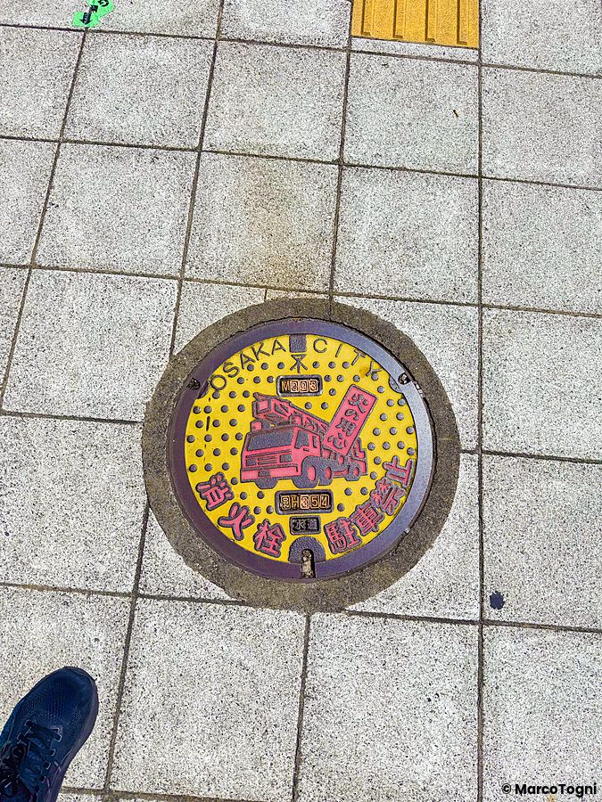 tombino colorato con disegno di camion dei pompieri ad Osaka